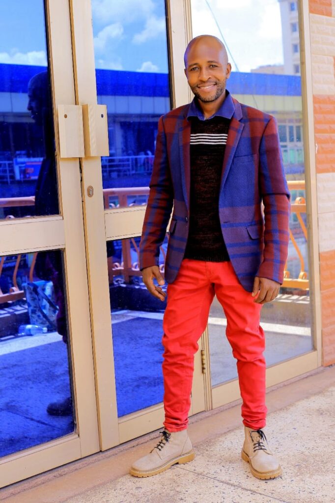Bryan Morel poses in dope blazer and red trouser